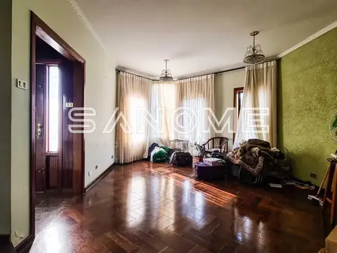 Sala ampla com piso de madeira e paredes verdes