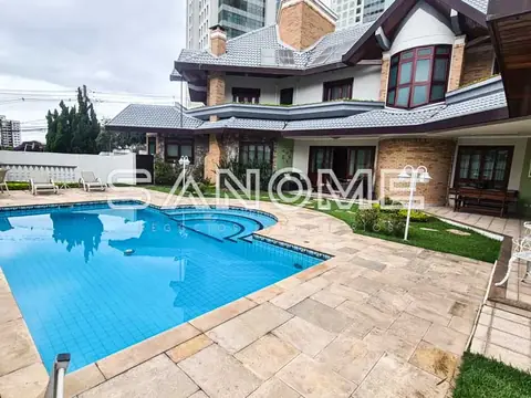 Área externa com piscina e casa ao fundo