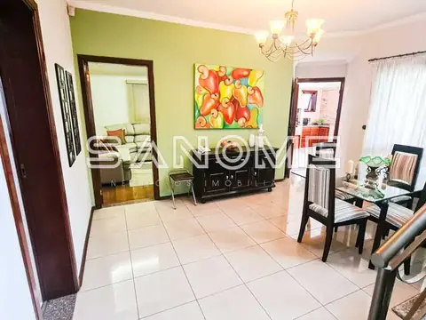 Sala de estar com parede verde e móveis pretos