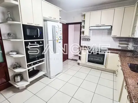 Cozinha planejada com armários brancos e bancada