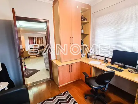 Escritório com mesa, computador e armários de madeira