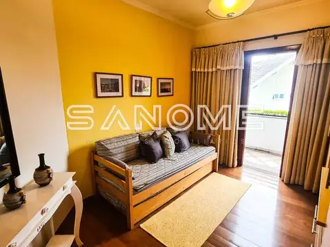 Sala com parede amarela e cama estilo solteirão