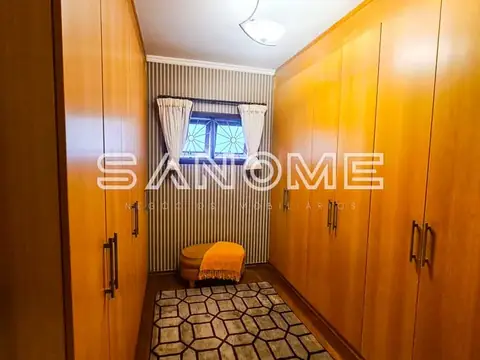Guarda-roupa amplo com portas de madeira e piso geométrico