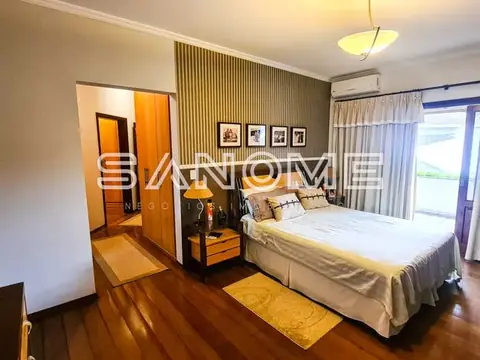 Quarto com cama de casal e piso de madeira