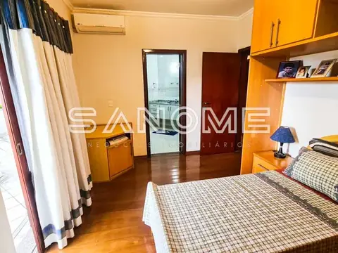 Quarto com cama de casal e móveis em tons quentes