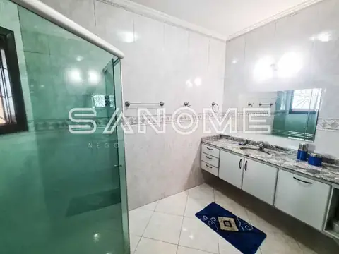 Banheiro com chuveiro em box verde e bancada branca
