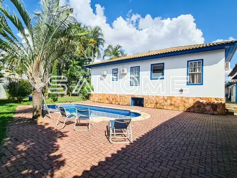 Casa branca com piscina e área de lazer