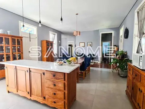 Cozinha integrada com ilha de madeira e bancada branca