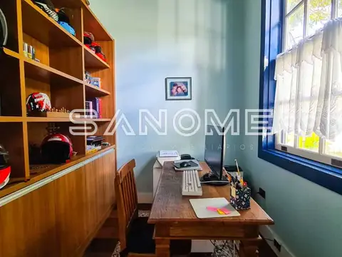 Escritório com mesa de madeira e estante