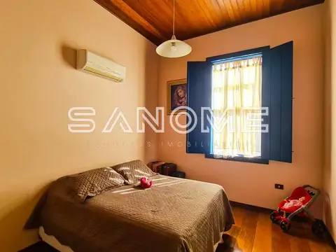 Quarto com cama de casal e janela azul