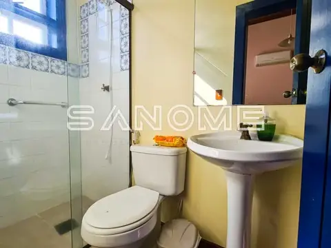 Banheiro com pia pedestal e box envidraçado