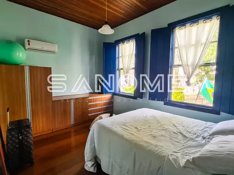 Quarto com cama de casal e janelas azuis