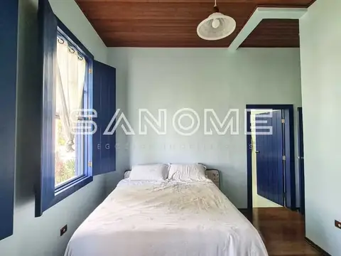 Quarto com cama de casal e janelas azuis