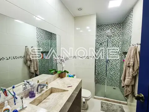Banheiro com pia dupla e box com azulejos verdes