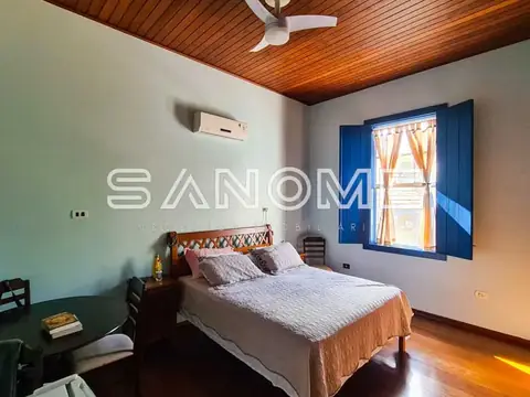 Quarto com cama de casal e janela azul