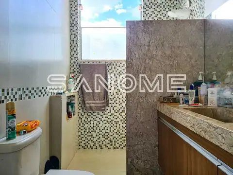 Banheiro com bancada, espelho e azulejos decorativos