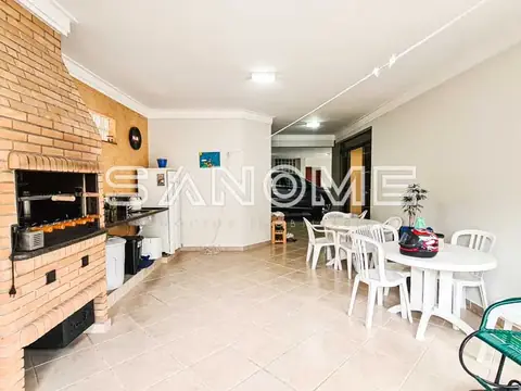 Sala de estar com churrasqueira e mesa de jantar