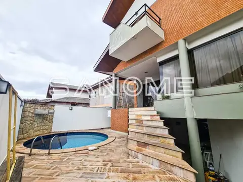 Área externa com piscina e casa de tijolos