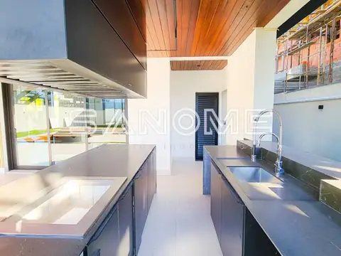 Cozinha com bancada, pias e vista para área externa