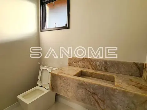 Banheiro com pia de madeira e vaso sanitário