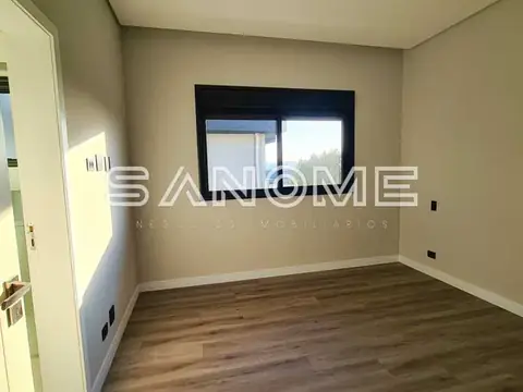 Quarto vazio com piso de madeira e janela
