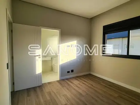 Quarto com porta aberta e janela com vista externa