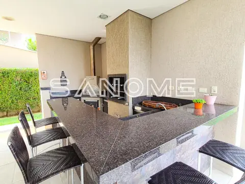 Cozinha com bancada cinza e churrasqueira integrada