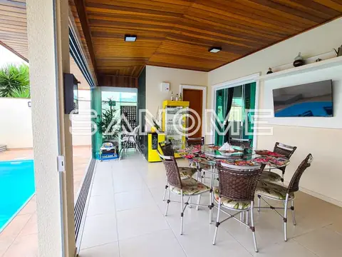 Sala de estar com mesa de refeições e vista para piscina