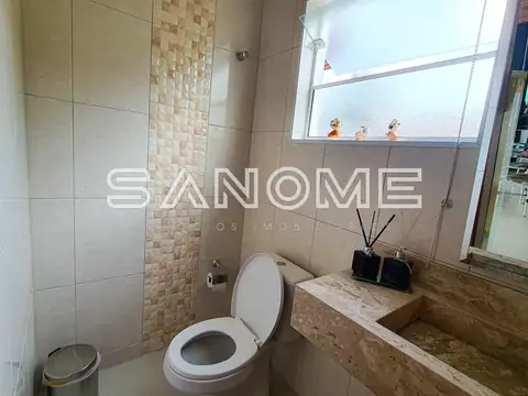 Banheiro com vaso sanitário e pia em granito