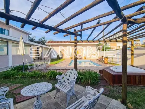 Área externa com pergolado e móveis de jardim
