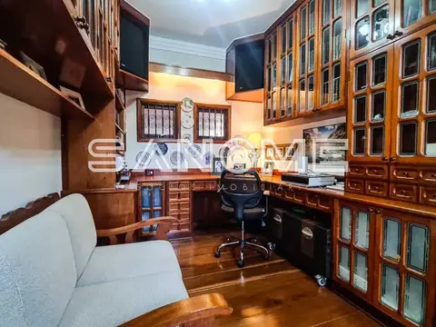 Sala de trabalho com móveis de madeira e estante