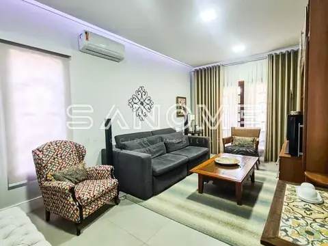 Sala de estar com sofá cinza e poltrona estampada