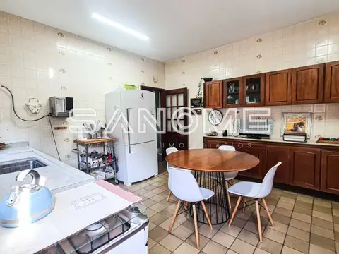 Cozinha com mesa redonda e cadeiras brancas
