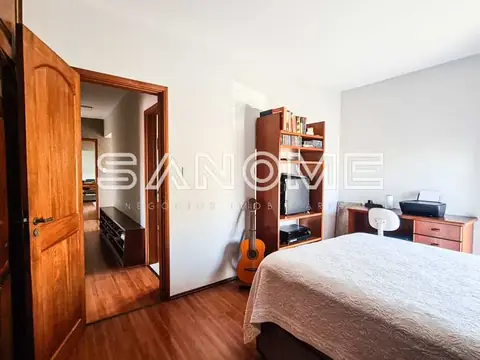 Quarto com cama de casal e móvel de madeira