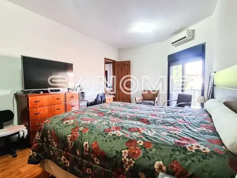Quarto com cama de casal e móvel em madeira