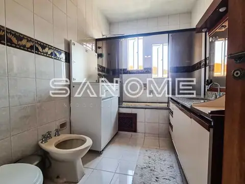 Banheiro com pia, vaso sanitário e box de vidro