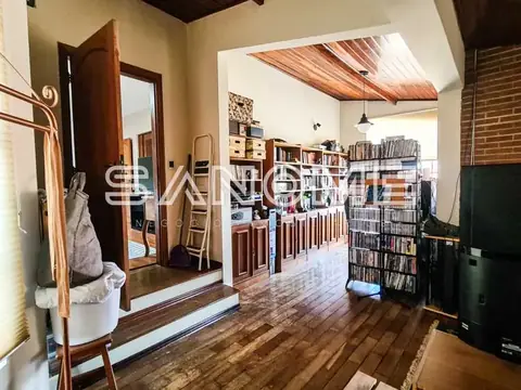 Sala ampla com estantes, espelho e piso de madeira