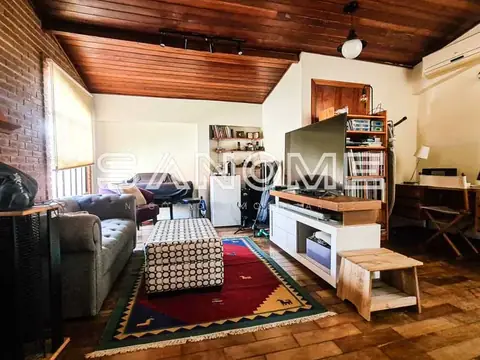 Sala de estar com sofá, estante e piso de madeira