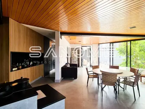 Sala integrada com teto de madeira e vista para área externa