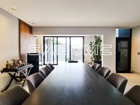 Sala de jantar com mesa comprida e cadeiras pretas