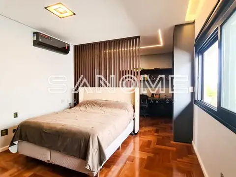 Quarto com cama de casal e painel de madeira