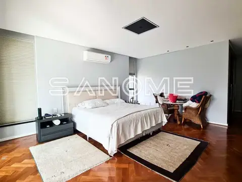 Quarto com cama de casal e piso de madeira