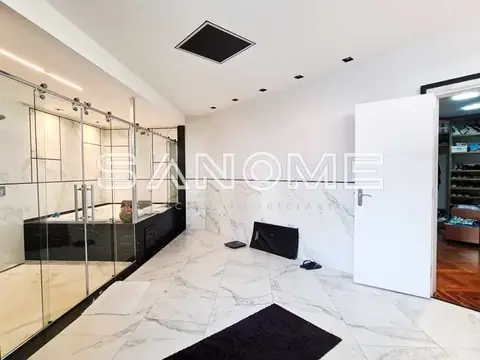 Banheiro com banheira, box e piso em mármore