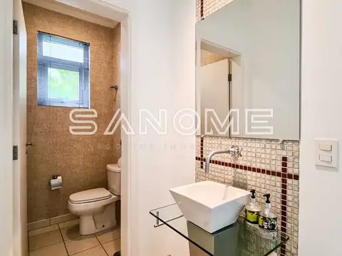 Banheiro com pia branca e azulejos decorativos