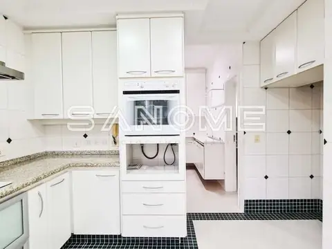 Cozinha planejada com armários brancos e piso preto