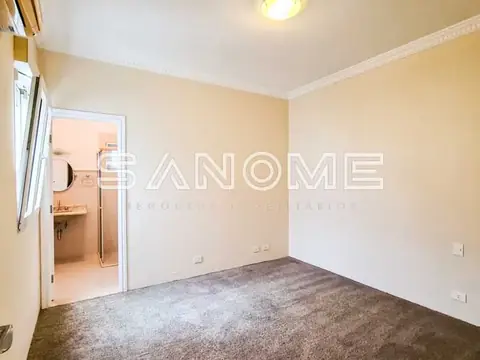 Quarto vazio com carpete e porta aberta para banheiro