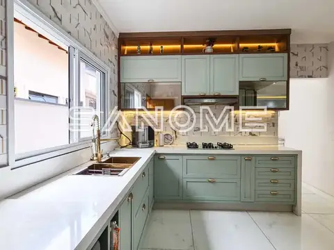 Cozinha planejada com armários verdes e bancada branca