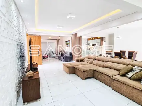 Sala de estar com sofá em L e teto com iluminação