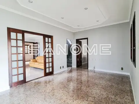 Sala com piso de granito e portas de vidro para quarto