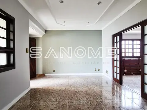 Sala ampla com piso de mármore e portas de madeira
